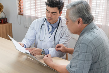Obraz premium Doctor explaining health examination results with elderly patient at home visit