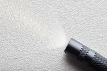 Black flashlight with a beam of light on White background