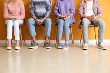 Young people waiting in line near color wall