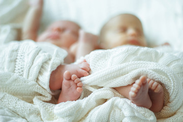 baby legs closeup wrapped in a white blanket blurred background