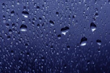 Water drops on blue background, top view