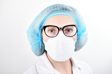 Portrait of young woman wearing medical uniform and mask with infection text isolated on white background. Protect your health.Nurse in mask headdress isolated on a white background.