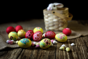 Easter composition on wooden background with rabbit figure. Hand painting Easter eggs. The concept of religious holidays, family traditions. Selective focus.