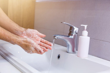 man washes his hands at home