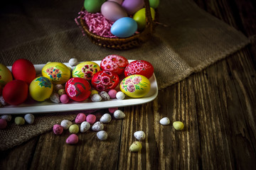 Easter composition on a wooden background. Hand painting Easter eggs. The concept of religious holidays, family traditions. Selective focus.