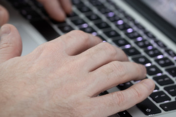 Image of man's hands typing. Selective focus