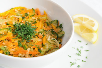 raw vegetables dill salad dressed with oil and lemon juice and decorated with dill and lemon