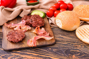 Ingredients for tasty burger on wooden table