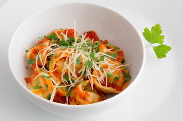 a bowl of ravioli with tomato sauce and cheese 