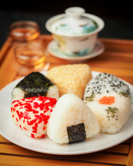 tea ceremony and different handmade onigiri close-up. traditional japanese food with kettle and mugs.