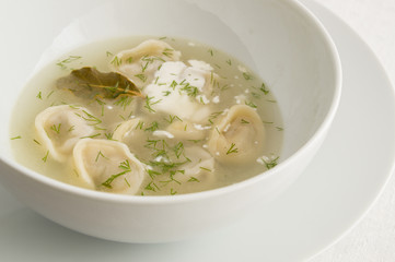 pelmeni in broth with dill and sour cream