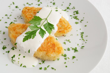 white cabbage cutlets with sour cream decorated with parsley