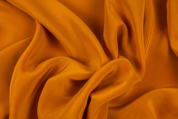 Golden silk or satin luxury fabric texture can use as abstract background.