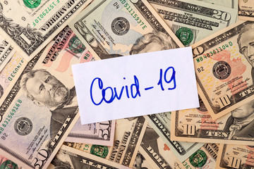Inscription COVID-19 on USA dollar banknotes, concept of the global financial crisis