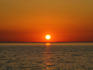 Sunset over the calm sea. Sunset orange sky reflection over the sea