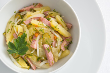 winter salad of potato, sausage, pickled cucumber, hot pepper, and onion with dill and oil