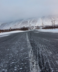 Scenic view on the dark empty road at the Norilsk in the Putorana Mountains during the Winter. North road