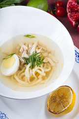 White bowl of egg noodle soup