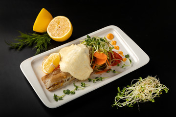 White fish fillet under sauce on a plate against
