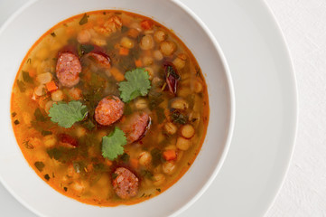 pea soup with sausages decorated with cilantro leaves
