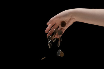 ruble coins fall from the hand down on a black background, the concept of the ruble's depreciation,...