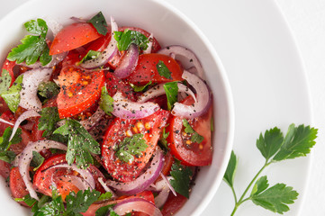 red onion tomato salad with parsley and black pepper