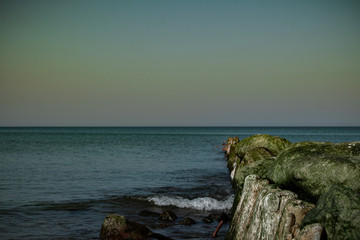view of the rocky beach of the sea or ocean in sunny weather with clear blue sky