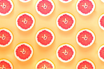 Fruit summer pattern with sliced grapefruit. Flat lay composition on yellow background. top view
