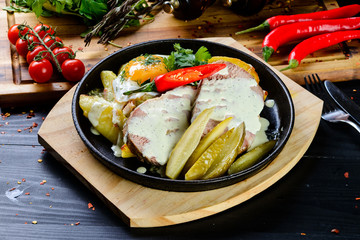 pan-fried home-made food fried eggs, potatoes and pickles