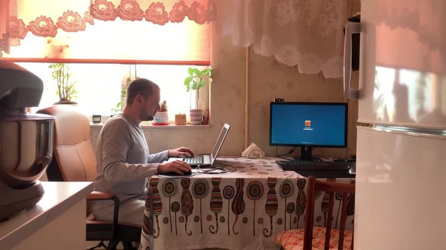 remote work at home in quarantine in self-isolation mode during a pandemic of covid-19. working from home with laptop. social distancing and stay home concept. man is sitting at the table