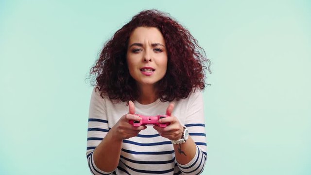 excited girl with joystick isolated on turquoise