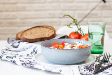 Fresh healthy salad with tomatoes, grilled pepper, cheese, pumpkin seeds and black sesame.