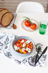 Fresh healthy salad with tomatoes, grilled pepper, cheese, pumpkin seeds and black sesame.