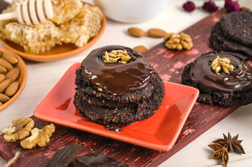 Vegan, vegetarian raw food healthy nut-banana chocolate brownie pastry on a white wooden background. Homemade from dates, walnuts, almonds and chocolate.
