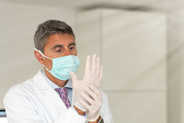 Confident doctor wearing mask and gloves at the medical studio in coronavirus times