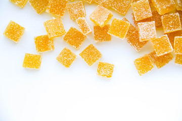 Pineapple, lemon, vanilla pate de fruit (jelly, marmalade, fruit candy) covered with sugar. White background, top view. There is a copy space for your text.