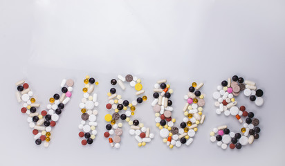 Multicolored tablets in the form of the word "stop virus" on a blue background. The view from the top. The concept of coronavirus.