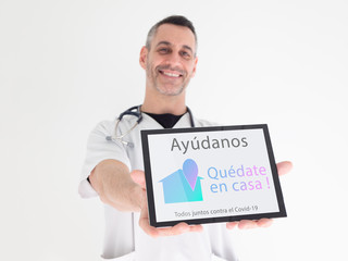 Handsome middle aged male doctor hands an advice written in spanish on his tablet : 