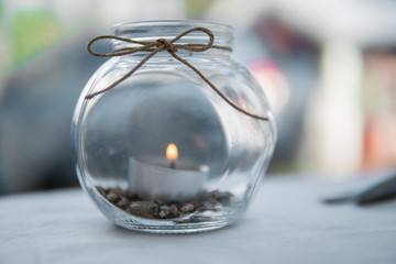 Tea light in a decorative glass in the summertime. Bright wedding decor concept.