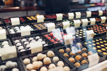 Assortment of candies desserts on cafe showcase. Variety of sweets with different flavours nuts spices in store.