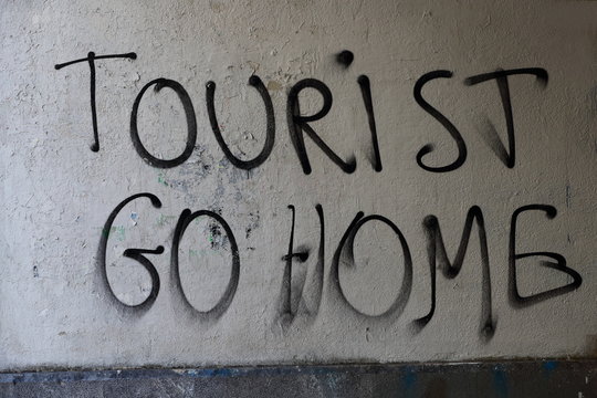 sign saying: tourist go home