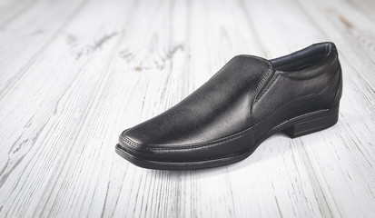 Black leather elegant shoes on gray background	
