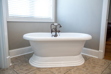 Obraz na płótnie Canvas Pure white retro old fashioned vintage new bathtub tub in a new construction bathroom with natural light