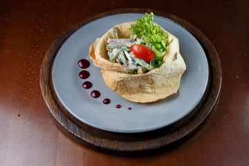 Salad in white bread on a blue plate.