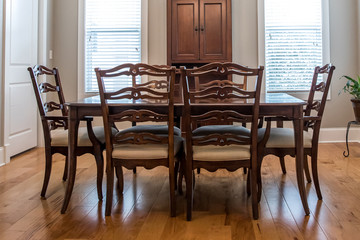 Formal Dining room with a set of wood table and chairs and a chandelier with windows and natural lights and hardwood floors
