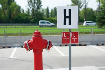 Red fire hydrant on a car park area. Sunny summer day