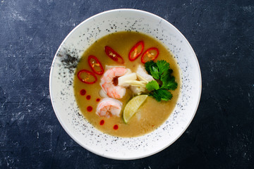 thai traditional tom yam kung soup in a white bowl