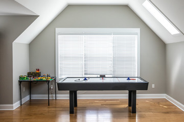 Open and airy upstairs loft game room near a window under an attic style ceiling with a window for...