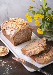 Homemade Pound, loaf nuts Cake with almonds sliced and chocolate Cream on rustic surface, selective focus. Spring, summer baking ideas concept. Copy space.