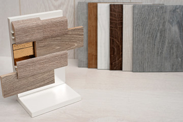 An example of a catalog of luxury vinyl floor tiles with a new interior design for a home or floor. An example of laying laminate and vinyl with lining and skirting.